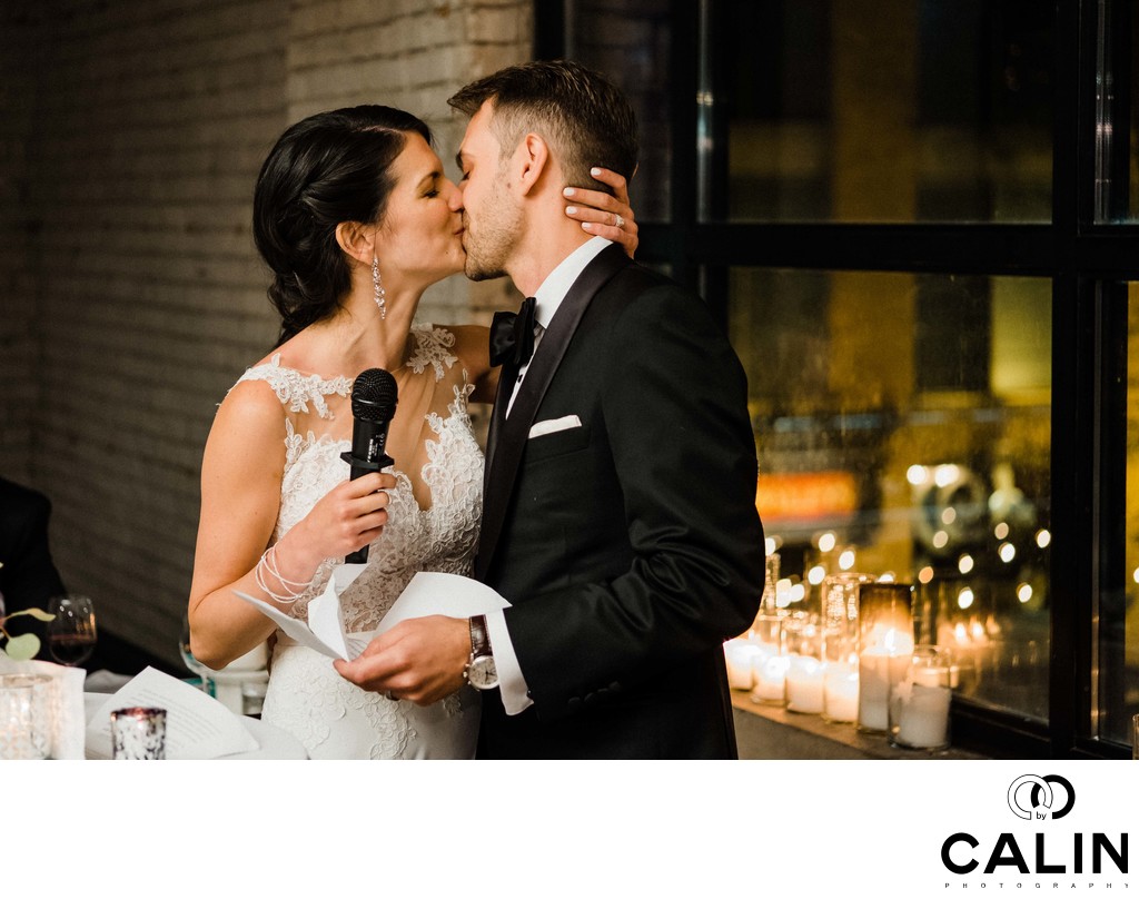 Bride and Groom Kiss During Speech at Storys Building Wedding
