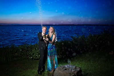 Engagement Photo of Couple Popping Champagne Bottle
