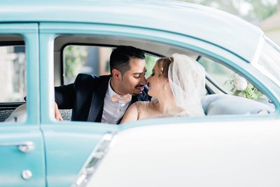 Bride and Groom Kiss in a Retro Car