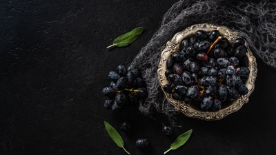 Black grapes in a silver vintage bowl with mohair scarf
