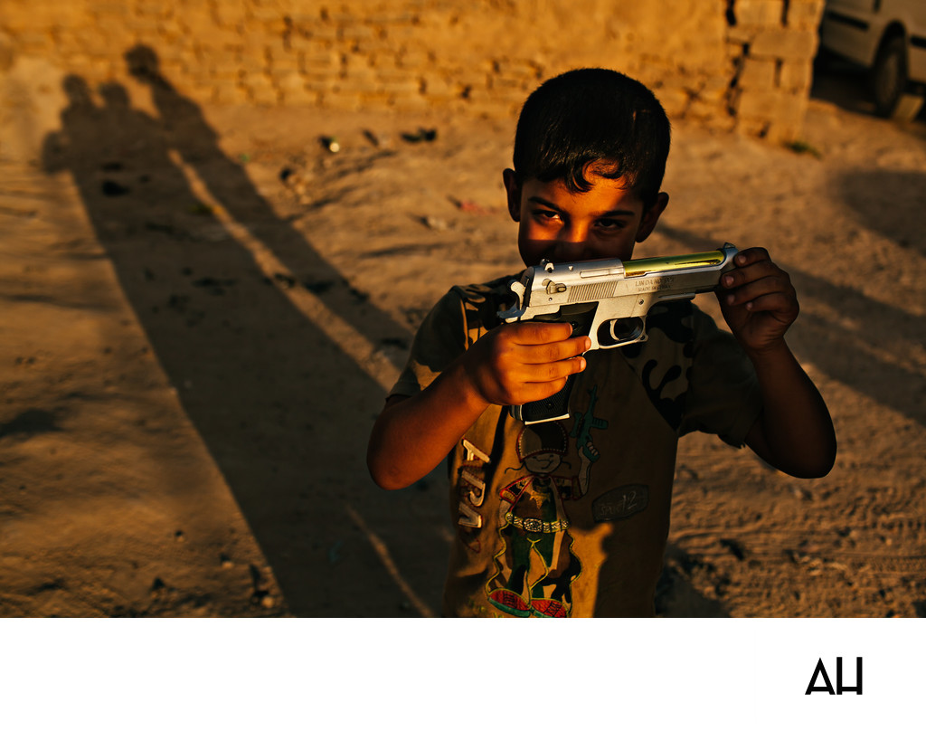 Boy Holding a Toy Pistol in Evening Light
