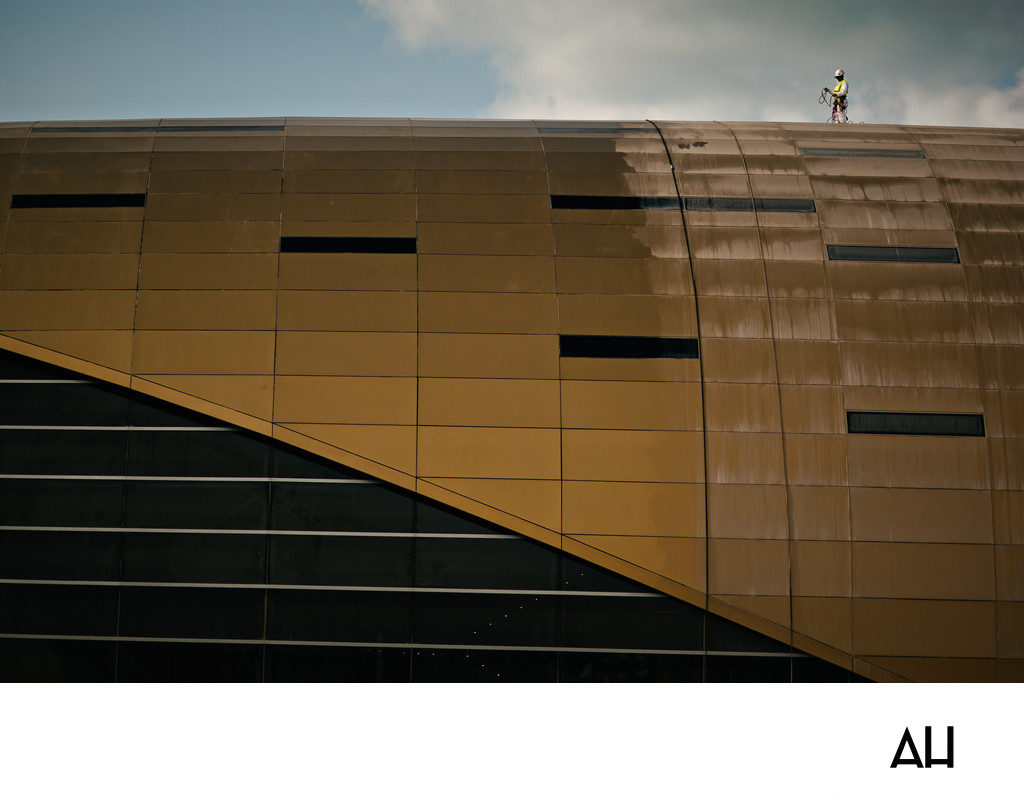 Worker Pressure-Washing a Modern Building Facade