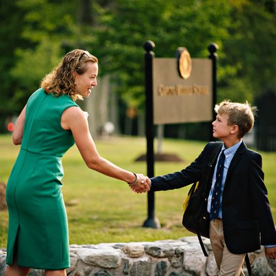 Teacher Welcoming a Student to Campus