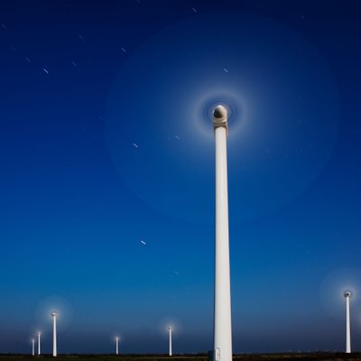 Wind Turbines Turning Under a Starry Night Sky