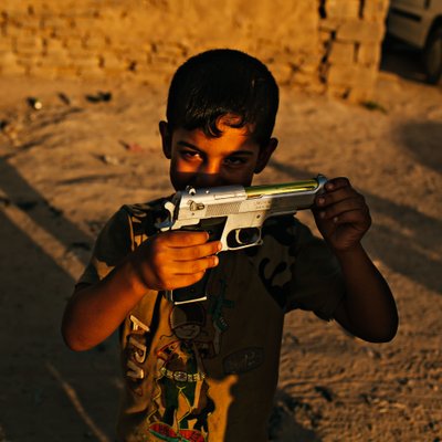 Boy Holding a Toy Pistol in Evening Light