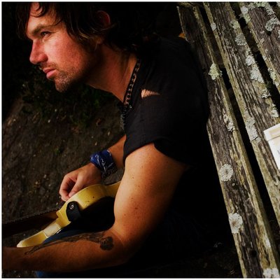 Musician Resting with His Guitar Outdoors