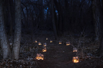 Candles along the path at sunrise in the bosque