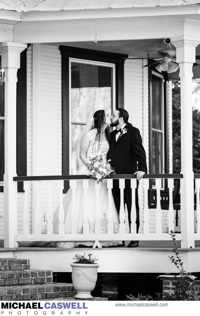 Couple Kisses on Porch at Henry Smith House Wedding