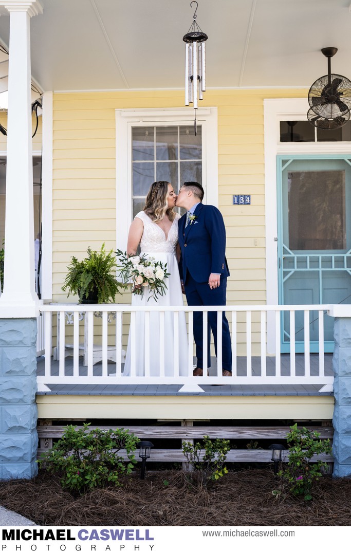 Brides Kiss on Porch of Home in Bay St. Louis