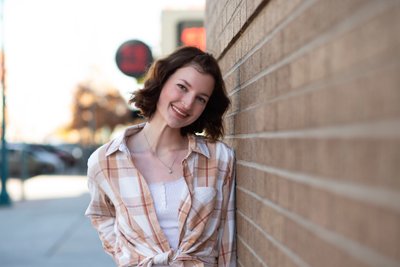 Senior Girl Leaning on Brick Wall Downtown