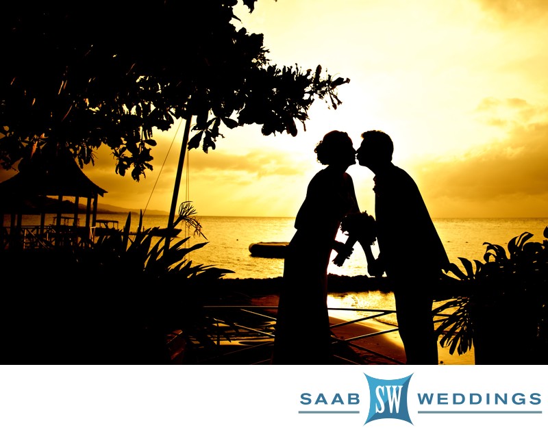 married couple silhouetted against Negril sunset 