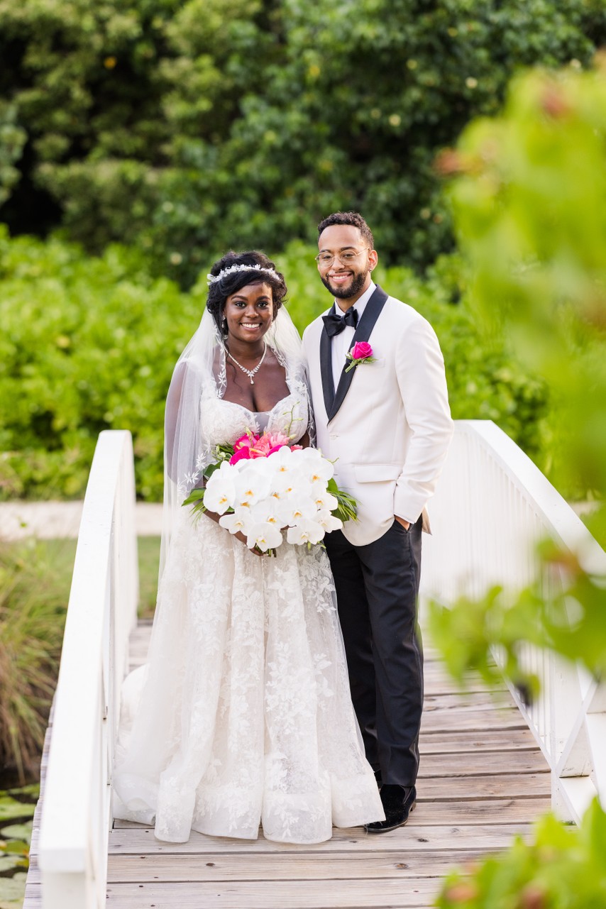 bride and groom standing on bridge