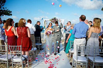 Bride and Groom leaving ceremony with beach balls