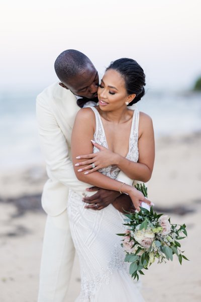 groom warms bride with his kiss as he holds her tight