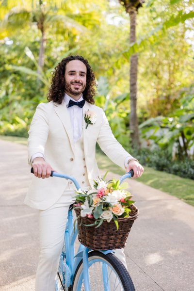groom on bicycle with bride's bouquet 