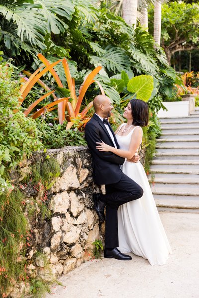 bride and groom leans casually on wall