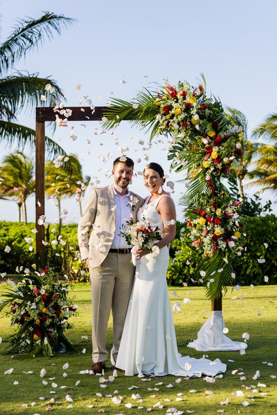 couple at arch with flowers thrown