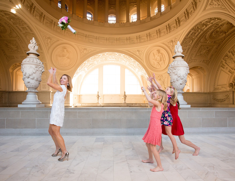 San Francisco City Hall Wedding Photographer | Mature Bride throwing bouquet on 4th floor
