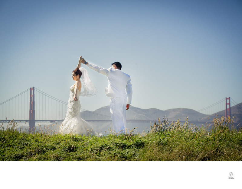 Wedding Couple in white, golden gate bridge in background dancing | San Francisco City Hall
