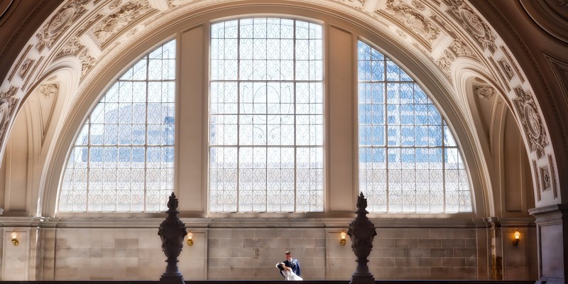  sf city hall photographer - couple on 4th floor in a with light streaming through windows