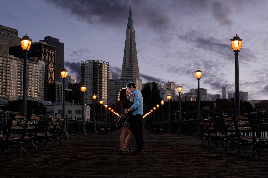 Newly engaged couple embrace Pier 7, Embarcadero, San Francisco