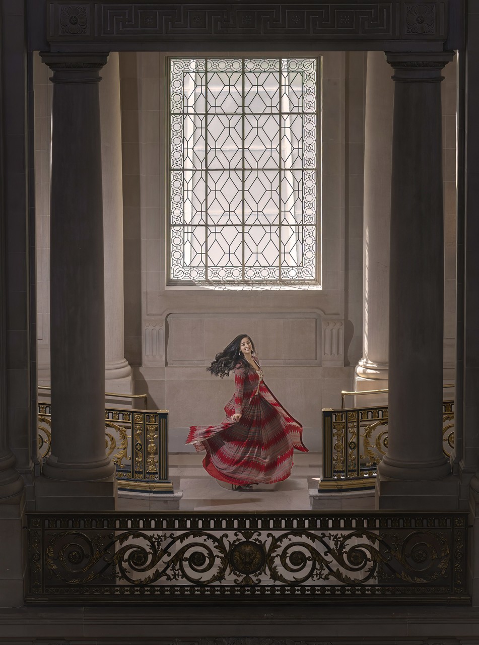 Elegant Woman in Red Spins Dress Ornate columns