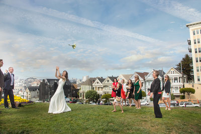 Bouquet-toss-in-front-of-the-painted-ladies