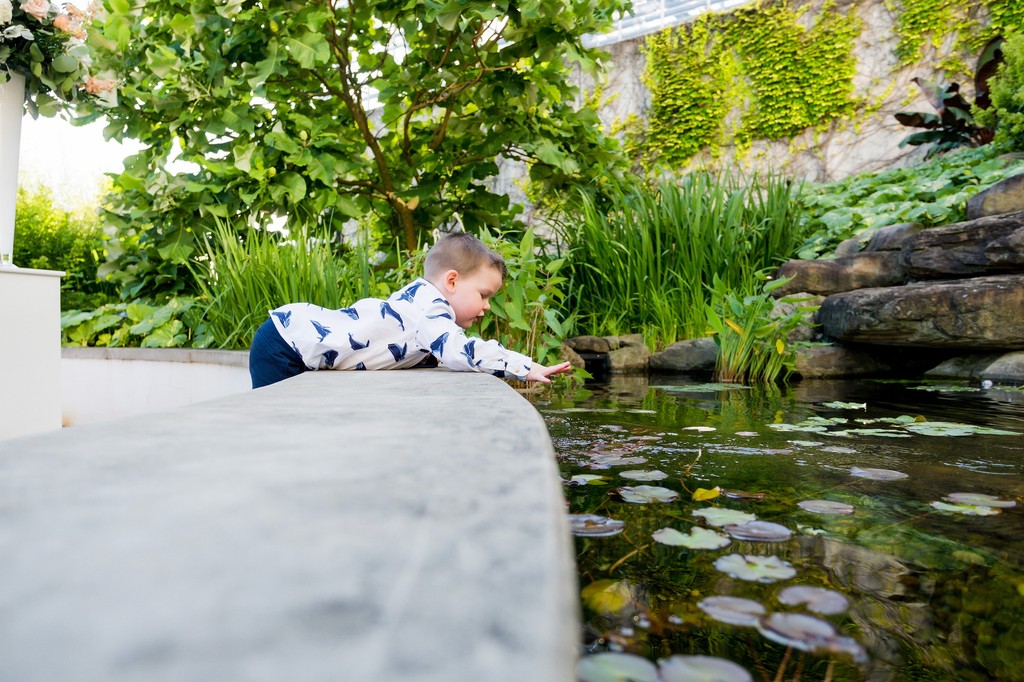 cute kid dropping coin into fountain at wedding
