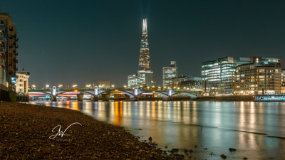 The Shard cityscape at night from shoreline of Thames