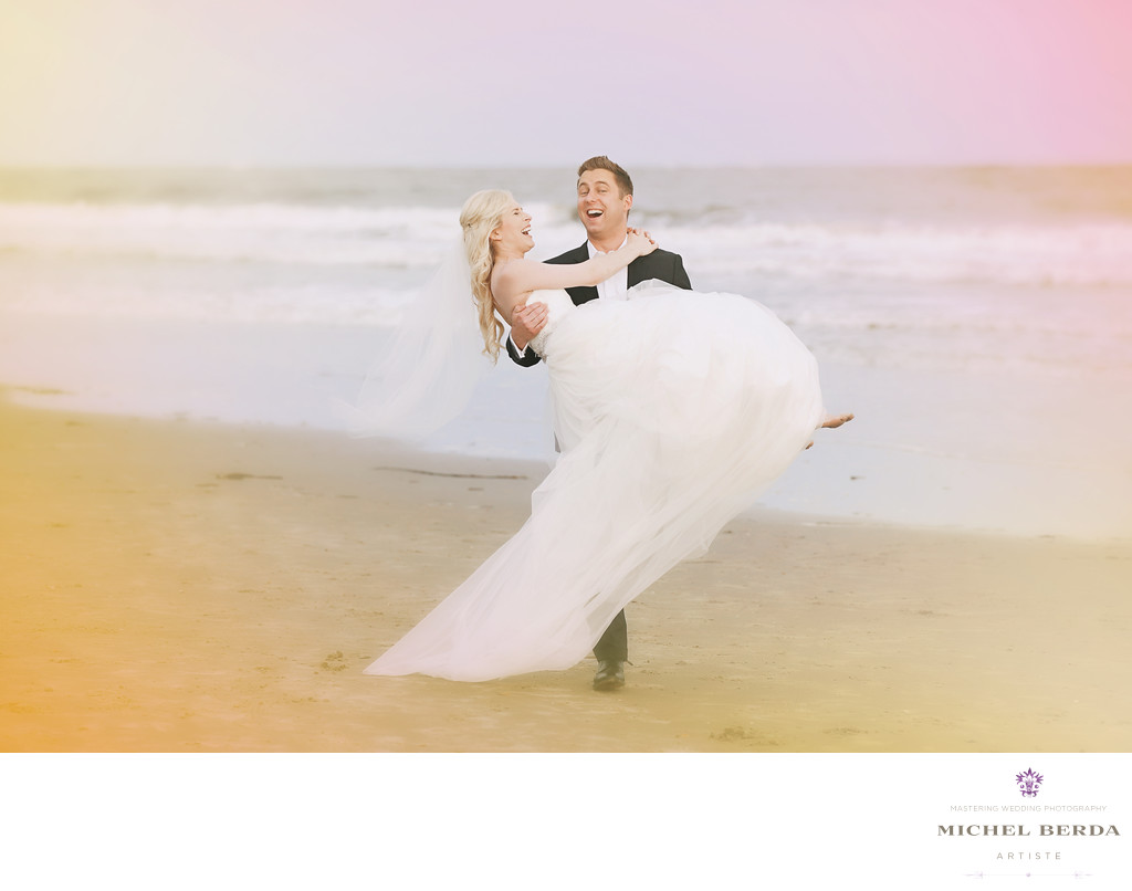Groom cariying bride on the beach wedding ceremony at Sea Side Point Wild Dunes Resort