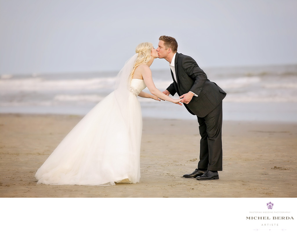 Bride and groom kiss on the beach wedding ceremony at Sea Side Point Wild Dunes Resort
