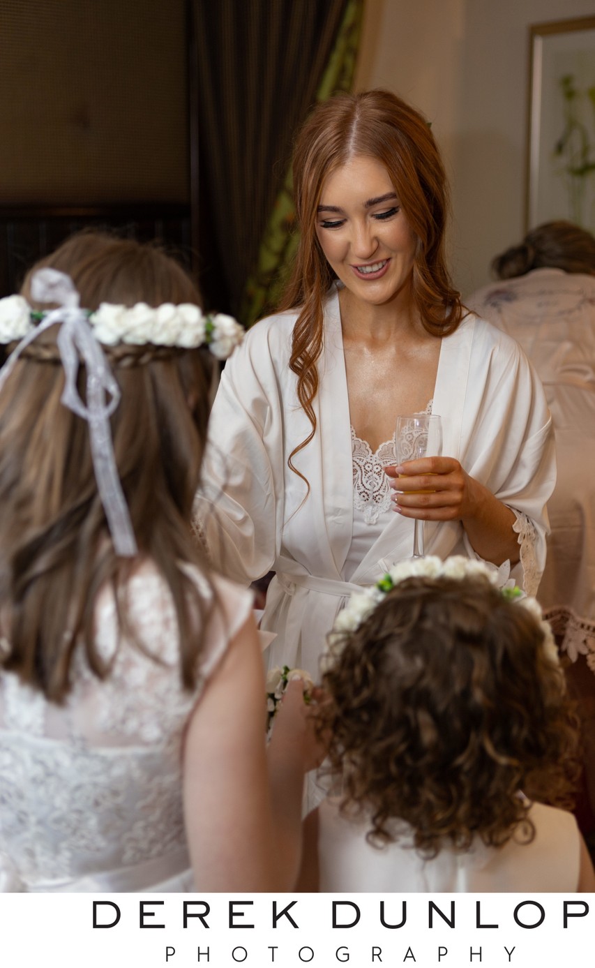 Bride and flower girl prep Brig o DoonThe bride and her flower girl share a wedding morning moment at Brig o' Doon. Gentle family photography in Alloway.