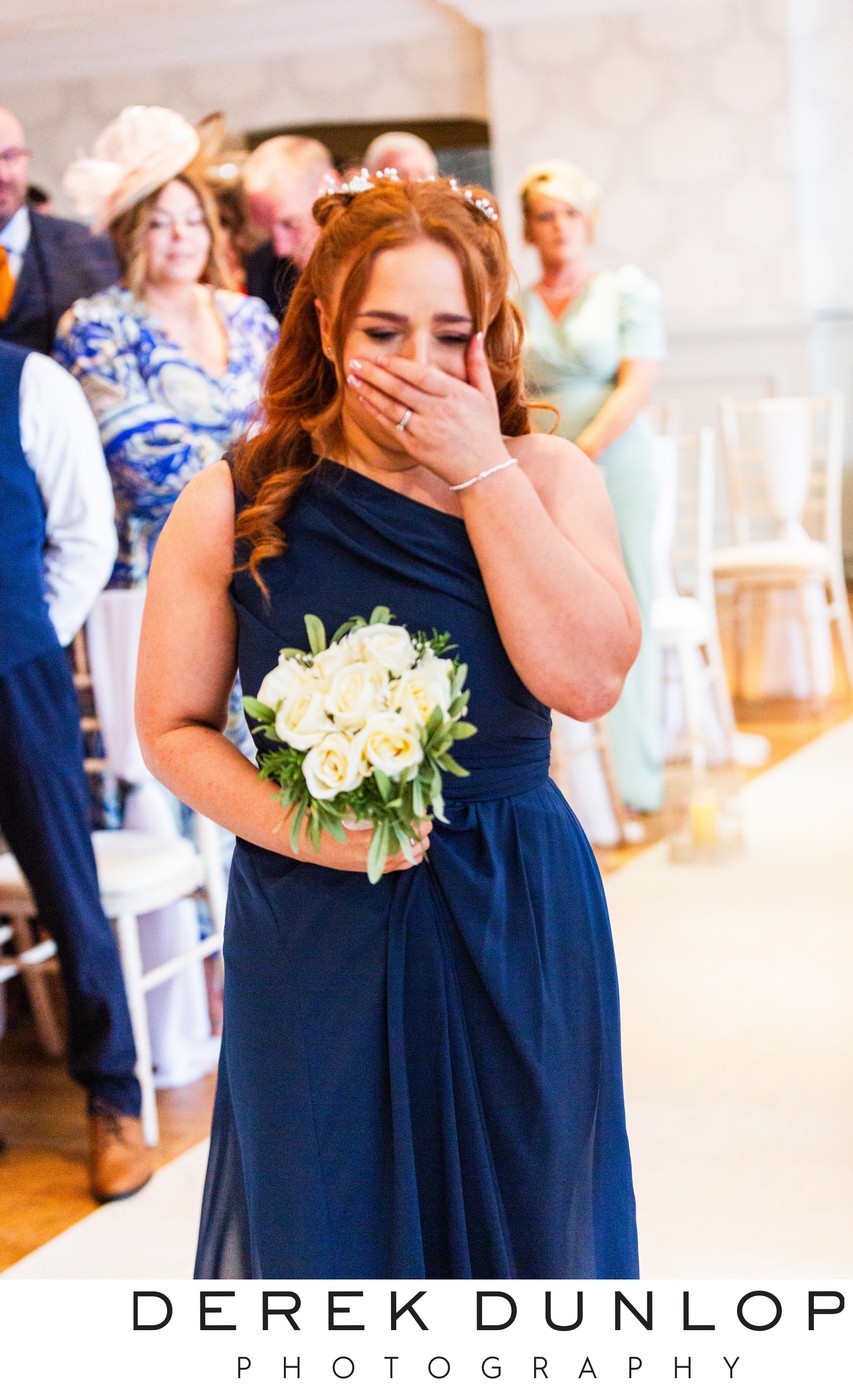 brides maid crying walking down the aisle