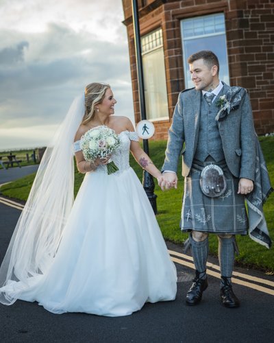 Bride and groom hand in hand Troon