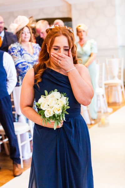 brides maid crying walking down the aisle