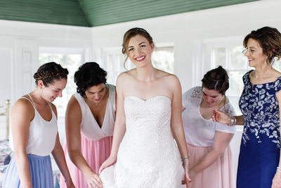 Fussing Bridesmaids with Smiling Bride