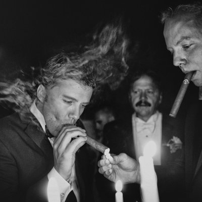 Groom and groomsmen enjoy post wedding cigars