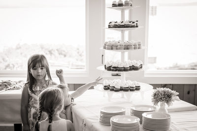 flower girl steals icing off wedding cupcake