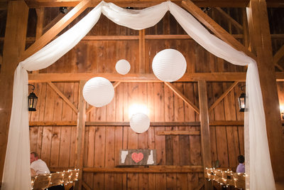 Wedding with white drapery barn rafters