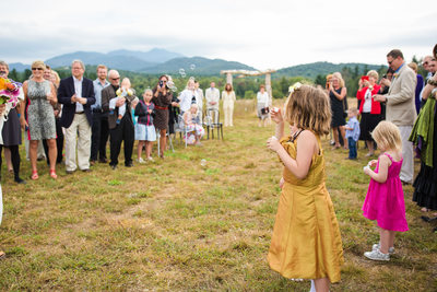 Little girl blowing bubbles VT wedding ceremony