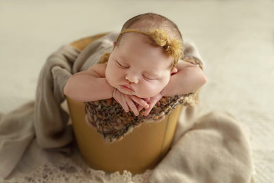 Baby wrapped in yellow with bow headband