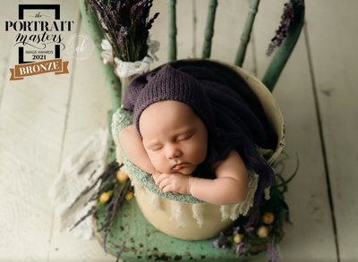 Baby wrapped in purple on chair with lavender 