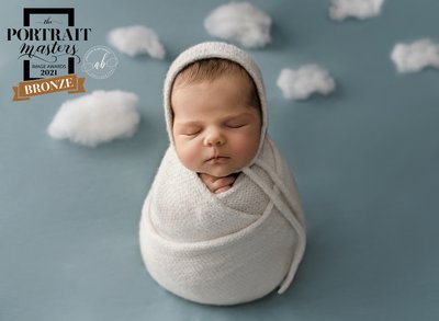 Baby wrapped in white in sky background