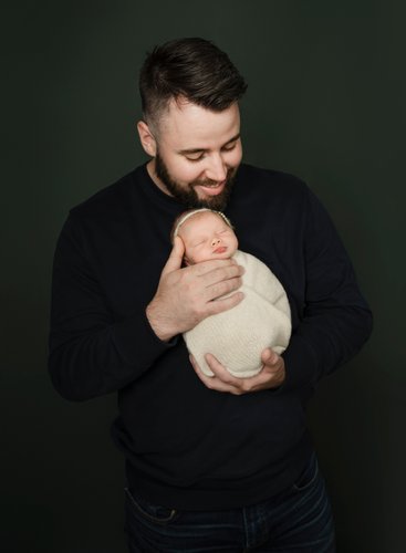 Wrapped baby in father's hands 