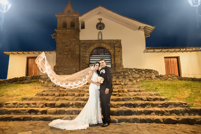 bride and groom in front of their church at night