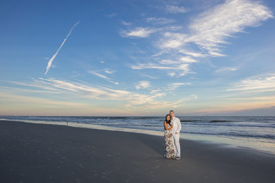 Engagement session at the beach at sunrise with blue sky