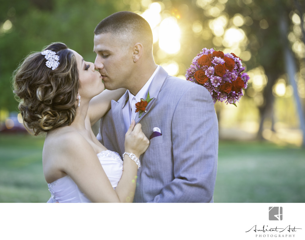 Bride and groom kissing with the bouquet. Clovis, CA 