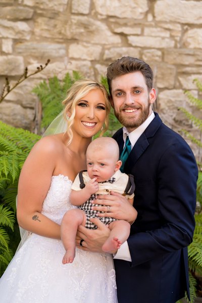 Bride and groom with newborn after ceremony St Charles
