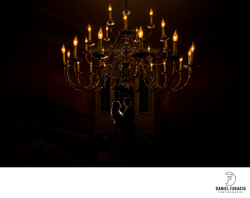 Bride and groom hugging under the grand chandelier 