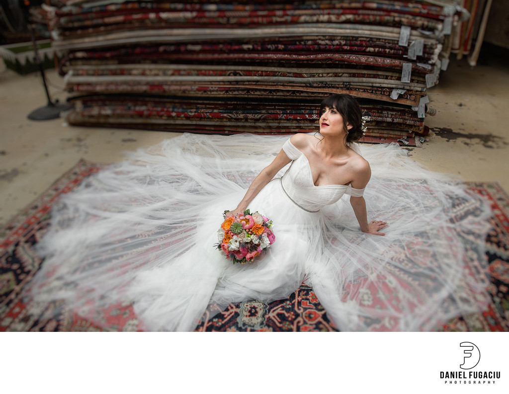 Bride holding bouquet posing on persian rug.